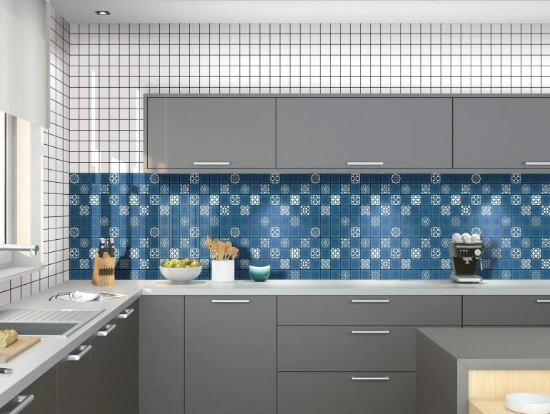 Elegant open kitchen design with grey cabinets, blue mosaic backsplash, and white tiled walls.